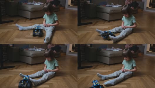 幼儿在地板上检查遥控玩具车高清在线视频素材下载