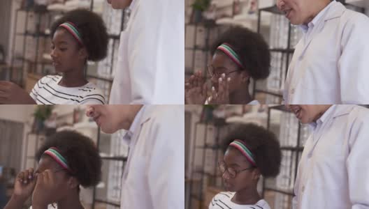 非洲少女在商店挑选新眼镜。高清在线视频素材下载