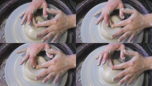 一个陶工学徒的双手正试图用陶工转盘上的一块粘土做一个杯子高清在线视频素材下载