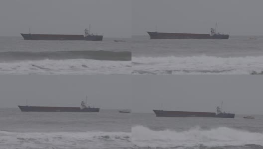 在暴风雨天气下，一艘油轮沿着一艘引航船在波涛汹涌的海面上行驶的特写镜头高清在线视频素材下载