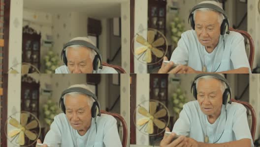 快乐的亚洲老人耳机在家听音乐高清在线视频素材下载