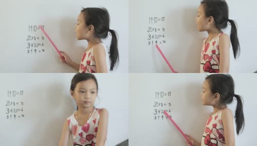 快乐的亚洲女孩在家庭教育期间在白板上写下数学科目的问题和答案，呆在家里的概念。高清在线视频素材下载