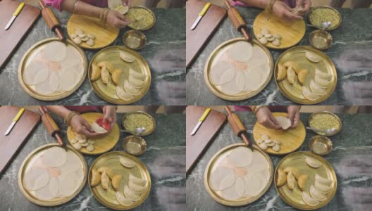 一位印度妇女正在准备古嘉，一种印度流行的小吃，特别是在胡里节的颜色高清在线视频素材下载
