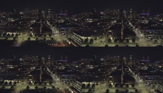 美国主要城市夜间的漂浮空中，人们在灯火通明的街道上开车高清在线视频素材下载
