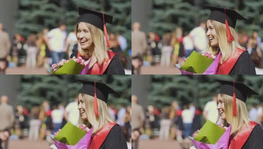 快乐美丽的毕业生手捧一束鲜花，对着镜头微笑高清在线视频素材下载