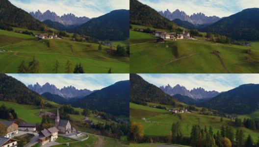 无人机拍摄的圣马达莱纳山村，在Geisler或Odle Dolomites群山前，Val di Funes, Trentino上阿迪杰。意大利,欧洲高清在线视频素材下载