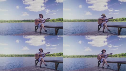 快乐的年轻亚洲女人在湖边和蓝天的背景，复制空间演奏古典吉他高清在线视频素材下载