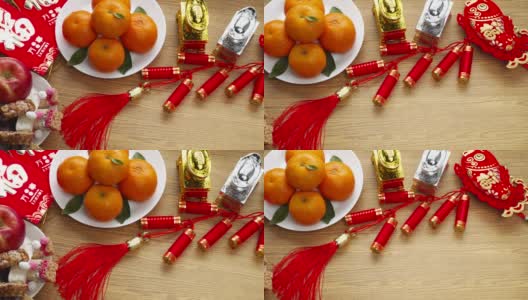 平铺中国新年节日装饰用橘子、苹果、葡萄和红包。文字以图像的形式出现，寓意好运高清在线视频素材下载
