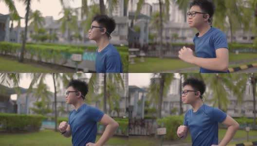 亚洲中国少年使用智能手表和骨传导耳机慢跑会话。高清在线视频素材下载