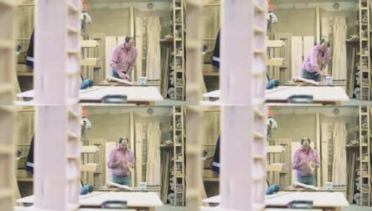 在这个小家具厂，手工工人——搬运工，用夹子把木质的细节粘在一起，做成成品。高清在线视频素材下载