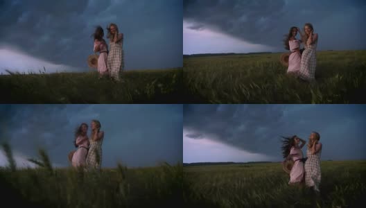 两个年轻迷人的女孩穿着衣服在雨中享受风与闪电的夏天，自由的概念，调情的概念高清在线视频素材下载