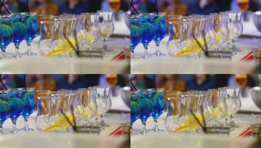 专业的调酒师将冰块和橙子放入玻璃杯中，并配以鸡尾酒高清在线视频素材下载