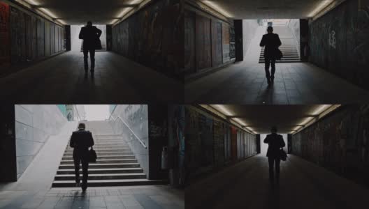 一个商人走出地下通道的剪影高清在线视频素材下载