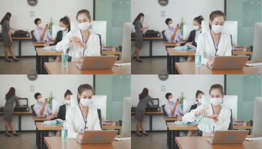 在新常态的办公室里，亚洲职场女性佩戴防护口罩、使用酒精凝胶洗手液以保持卫生，并保持社交距离，以防止冠状病毒新冠病毒的传播。高清在线视频素材下载
