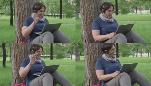 高级妇女有在线电话而坐在城市公园的草地上。教育的概念高清在线视频素材下载