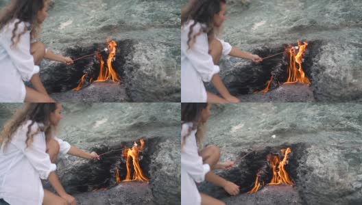 女士拿着棉花糖棒在chimmaera山火上高清在线视频素材下载