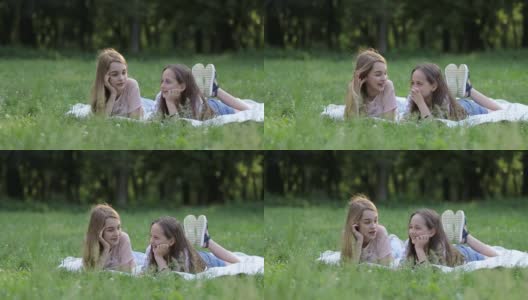 在一个阳光明媚的夏日，两个可爱的小妹妹在草地上玩耍高清在线视频素材下载