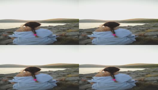 海边的一个年轻女子正在做瑜伽和冥想高清在线视频素材下载
