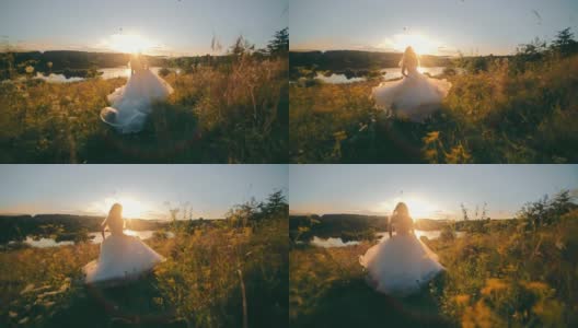 美丽的新娘在夕阳的映衬下奔向湖边。莫兰朗日的日落和背光的光线。年轻女子在长雪纺连衣裙高清在线视频素材下载