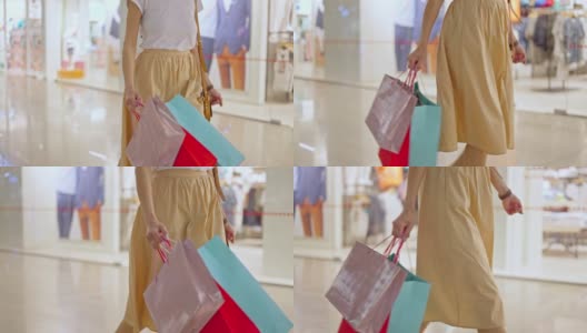 女人拿着购物纸袋走在商场里，享受购物高清在线视频素材下载