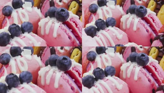 马卡龙手工制作的精美甜品，用新鲜草莓和蓝莓装饰的巧克力甜点，精致的黄色和粉色蛋糕，糖和健康食品高清在线视频素材下载