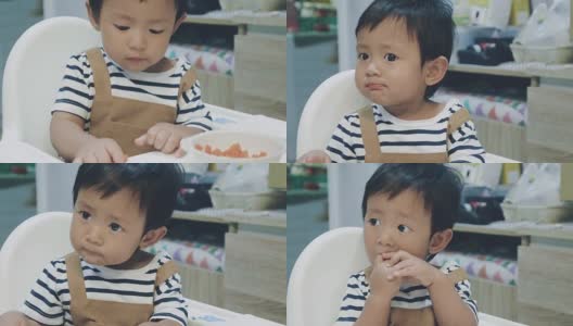 亚洲男婴在高椅子上吃东西。高清在线视频素材下载