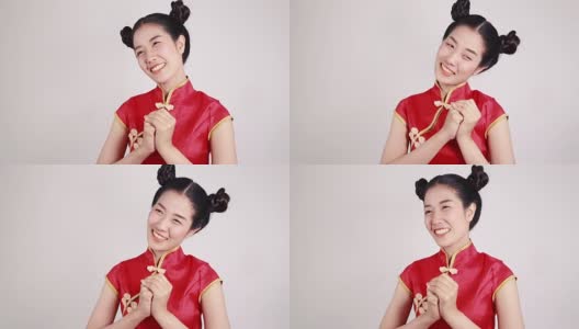 妇女穿着红色旗袍，用手势表示祝贺，寓意春节快乐高清在线视频素材下载