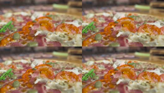 餐厅桌上的热披萨配西红柿和培根。正宗的意大利披萨，配上番茄、奶酪、橄榄。传统意大利美食，美食理念高清在线视频素材下载