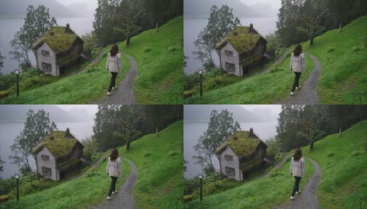 在挪威峡湾附近的村庄里散步的女人高清在线视频素材下载