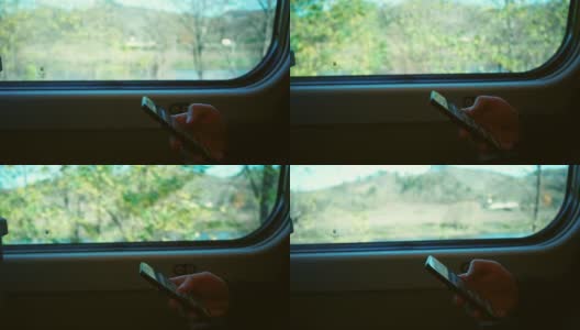 一个男人在靠近窗户的火车车厢里使用手机。高清在线视频素材下载