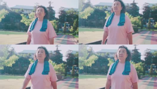 亚洲老年女性在阳光明媚的日子里在公园的跑道上散步，减肥控制肥胖，放松锻炼，退休生活积极活动高清在线视频素材下载