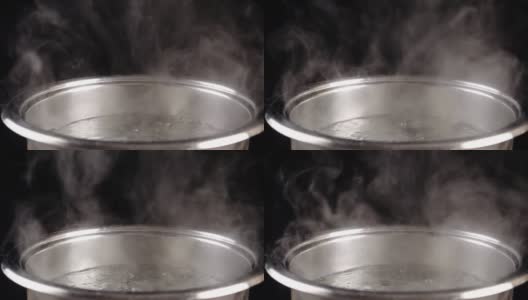 在黑色背景的金属锅里烧开的水，慢动作高清在线视频素材下载