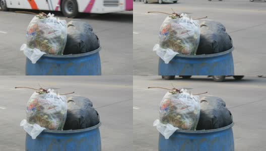 满垃圾桶的大垃圾袋装满了剩菜和垃圾在街上高清在线视频素材下载