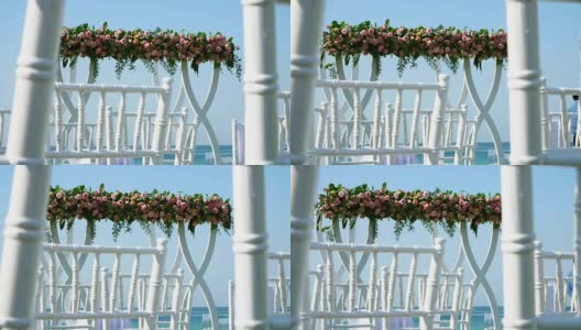 婚礼装饰，白色的婚礼拱门装饰着玫瑰，在海滩上举行婚礼仪式，在海滩上准备婚礼仪式高清在线视频素材下载