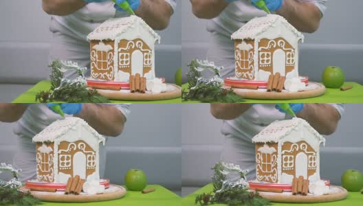 糖果师傅用奶油装饰姜饼屋高清在线视频素材下载