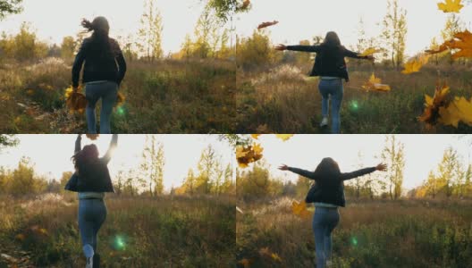 年轻女子跑过秋天的森林手里拿着黄叶的花束并把它们扔出去。女士在五彩缤纷的秋天森林里玩耍。日落时分，女孩在户外慢跑。慢动作高清在线视频素材下载