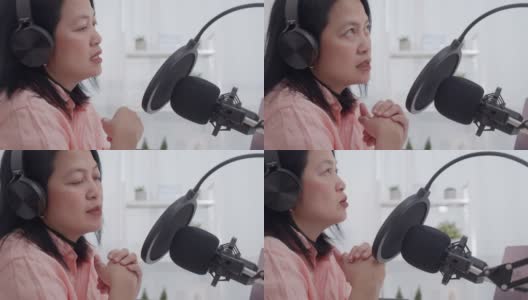 亚洲女性电台主持人录制播客在她的笔记本电脑与耳机和麦克风。女播客制作音频播客从她的家庭工作室的在线节目。高清在线视频素材下载