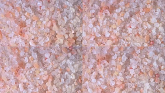 粉红色喜马拉雅盐。特写喜马拉雅粉岩盐在木勺黑色的背景。粉喜马拉雅盐的细粒高清在线视频素材下载