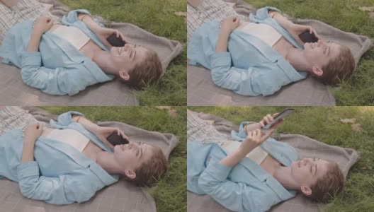 女人躺在草坪上打电话高清在线视频素材下载