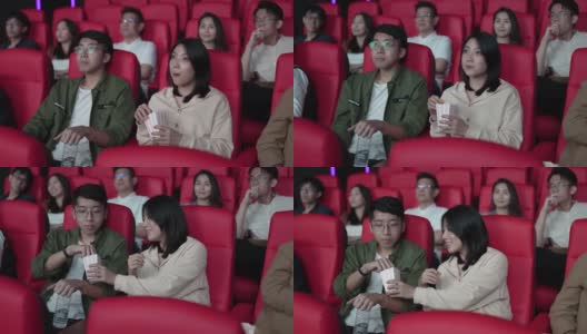 亚洲的中国年轻夫妇在电影院等待电影放映时分享食物，享受彼此的陪伴高清在线视频素材下载