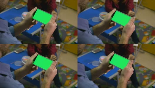 年轻女子正在听男人说话，手里拿着绿色屏幕的智能手机高清在线视频素材下载