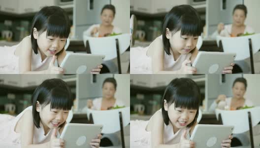 快乐的小女孩在平板电脑上看东西高清在线视频素材下载