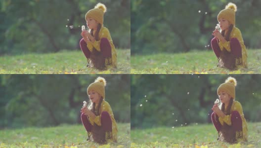 美丽的小女孩在秋天公园吹蒲公英花。希望，梦想，户外游戏时间高清在线视频素材下载