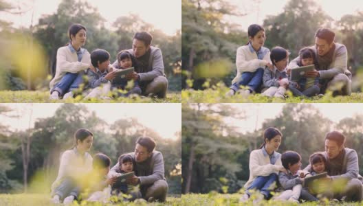 年轻的亚洲家庭在公园草地上放松高清在线视频素材下载