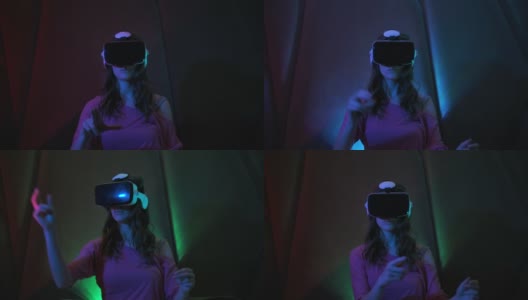 年轻漂亮的女孩使用虚拟现实眼镜。坐在霓虹灯下的黑暗房间里，戴着VR头盔玩游戏高清在线视频素材下载