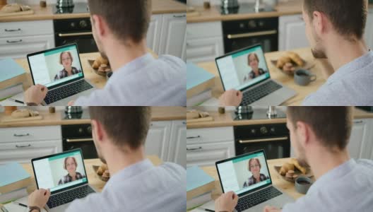 在厨房用笔记本电脑与老师进行在线视频学习高清在线视频素材下载