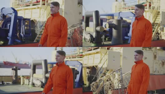 身穿橙色制服的港口工人正在货港工地上行走。Slowmotion高清在线视频素材下载