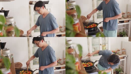 (中景)一个年轻人正在家里做饭高清在线视频素材下载