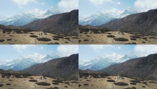 一对夫妇在尼泊尔喜马拉雅山Annapurna马戏团徒步旅行的Manang山谷，在Annapurna链和Gangapurna的景色。干燥和荒凉的景观。白雪覆盖着高耸的山峰。高清在线视频素材下载