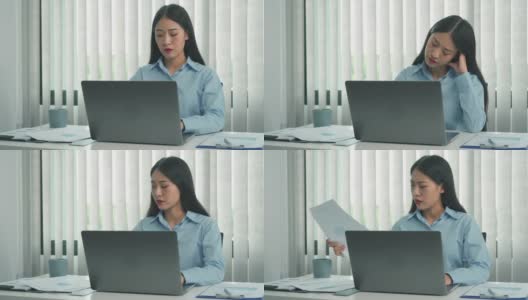 年轻的亚洲女性在办公室使用笔记本电脑时，对文件感到沮丧。高清在线视频素材下载